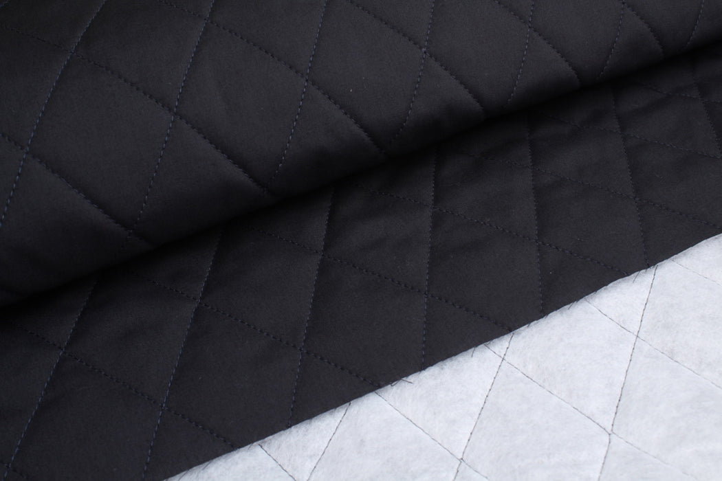 Black quilted fabric on a white grid background