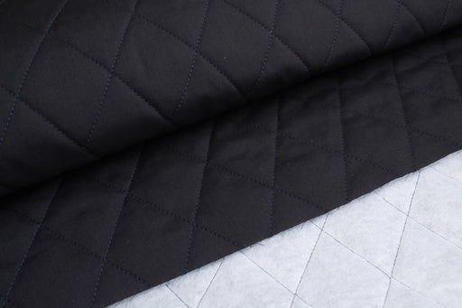 Black quilted fabric on a white grid background